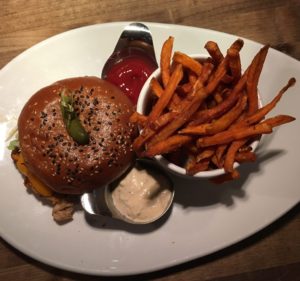 Blackened Chicken Burger with crisp pancetta bacon, American cheddar, roasted garlic mayo, toasted sesame broiche